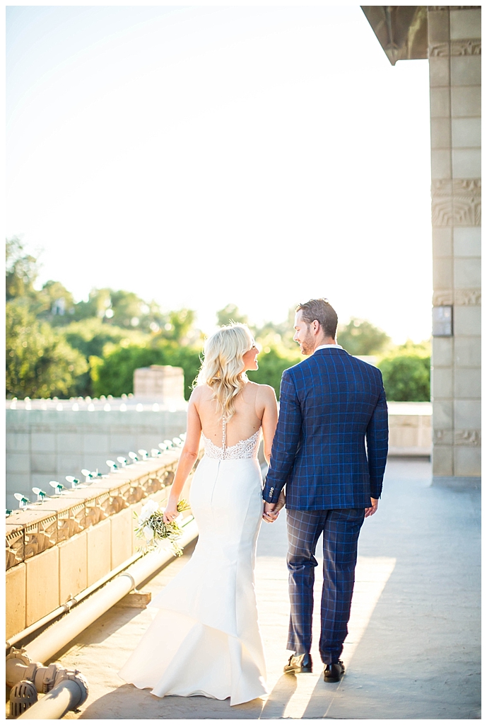 bride in two piece wedding dress and groom in custom blue suit on the rooftop at Arizona Biltmore