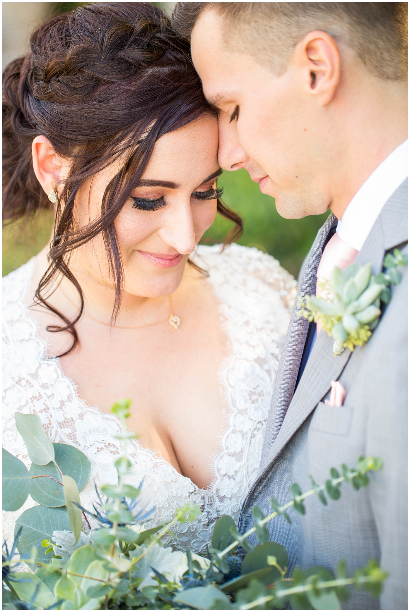 Bride in sleeved white dress and groom in gray jacket