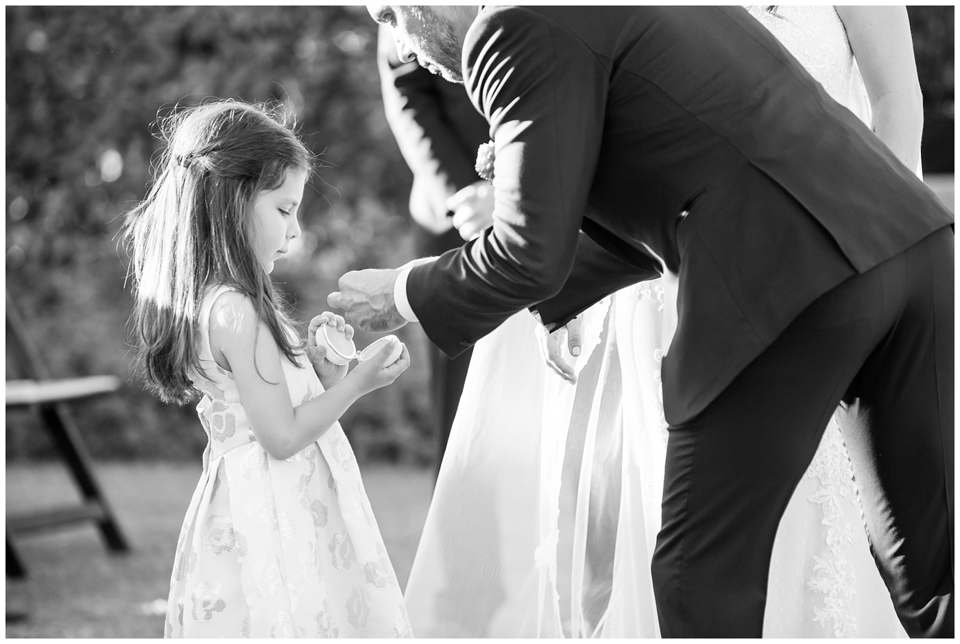 Flowergirl giving the groom the wedding rings during ceremony