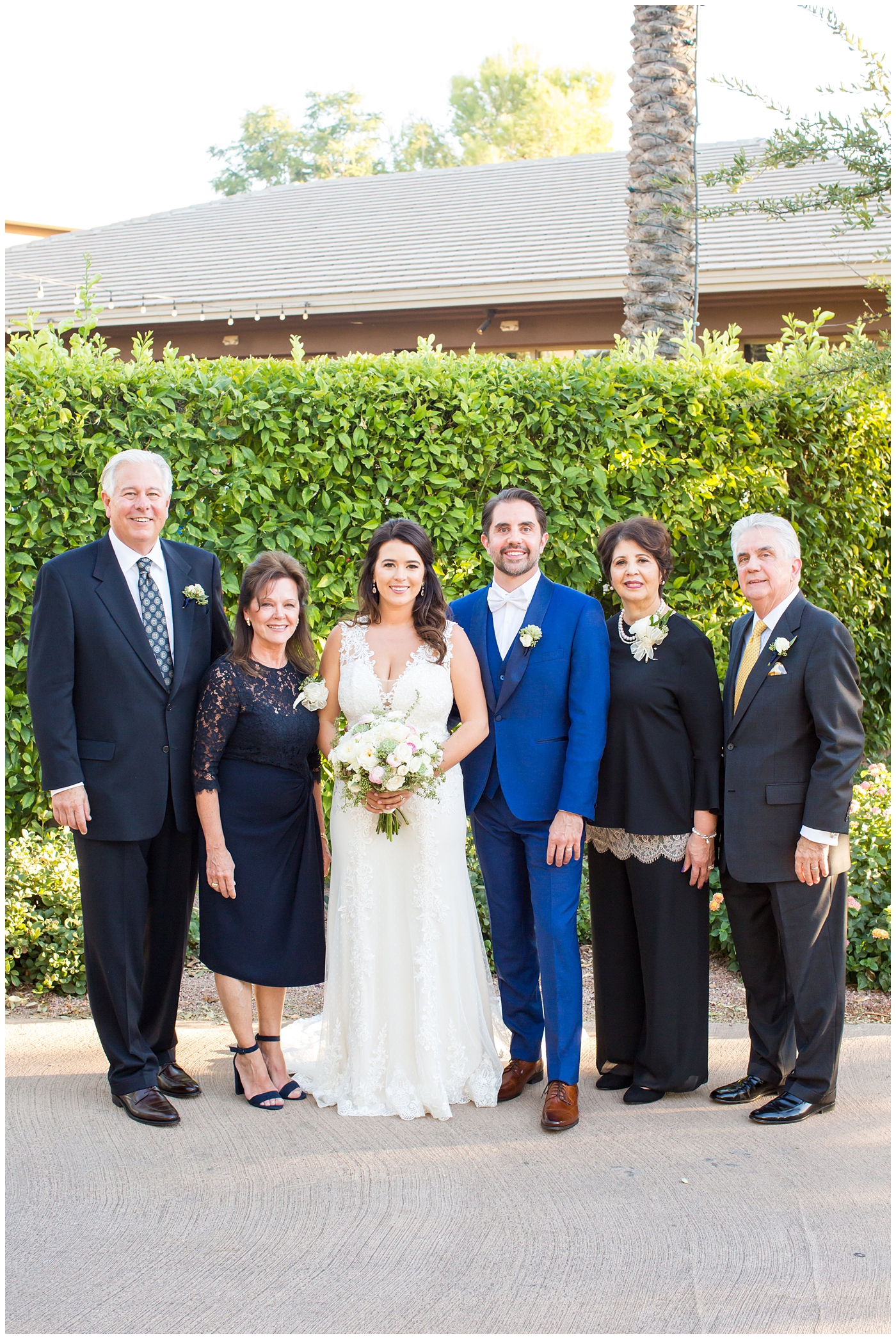 Bride in Justina Alexander dress with groom in custom Brother's Tailors blue suit family portraits