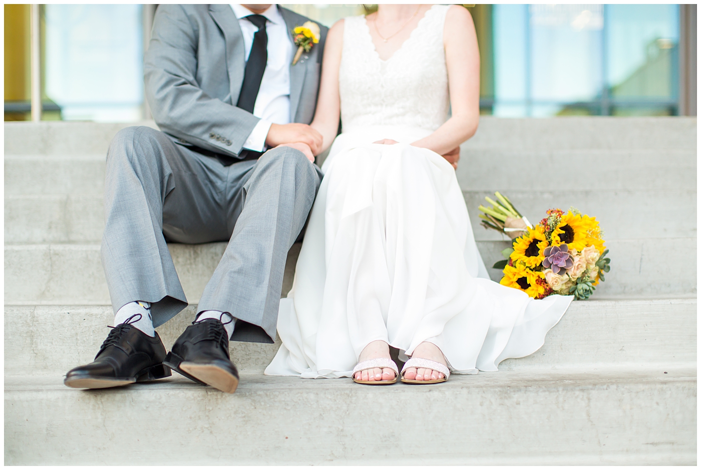 bride in white dress with sunflower and succulent bouquet and groom in gray suit wedding portrait