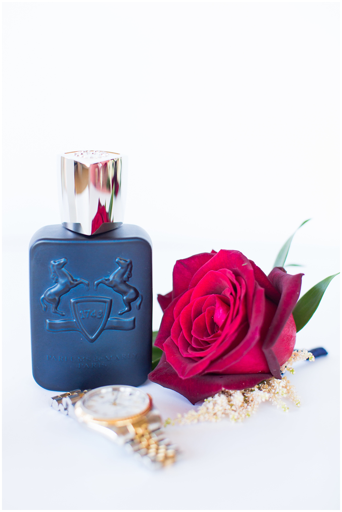 groom cologne with red rose boutonniere and watch