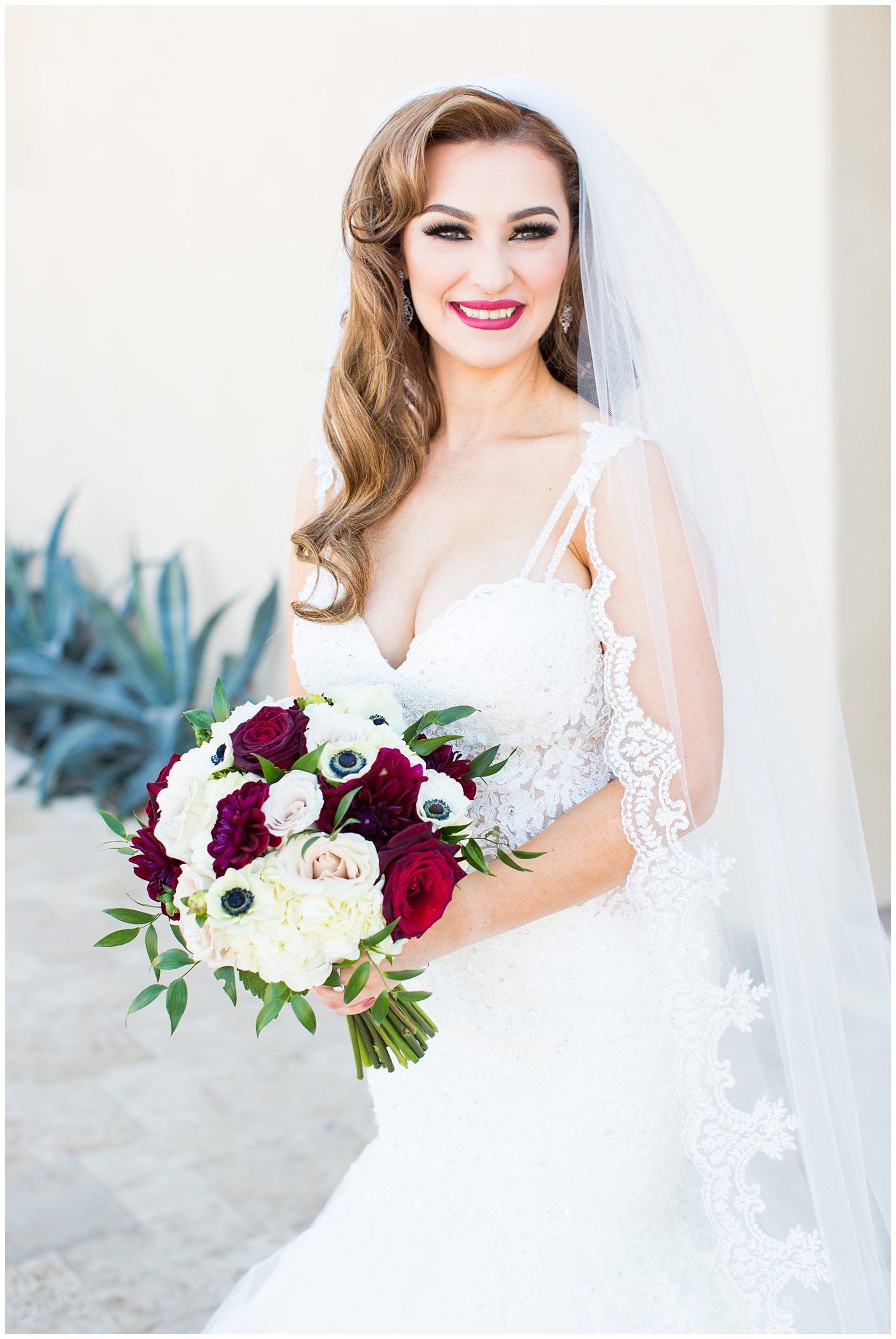 bride in morilee wedding dress with red and white rose bouquet 