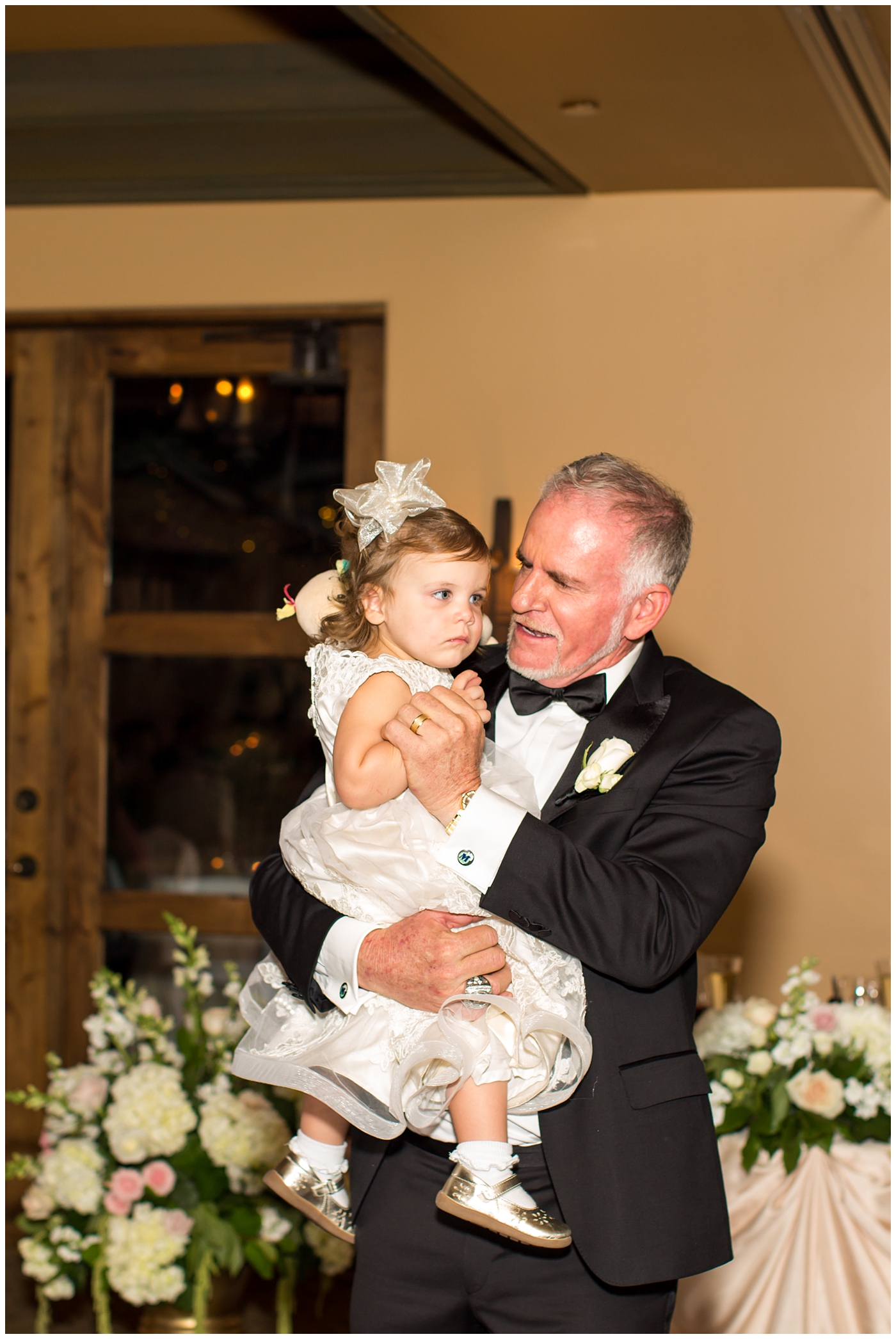 groom in black tux with granddaughter