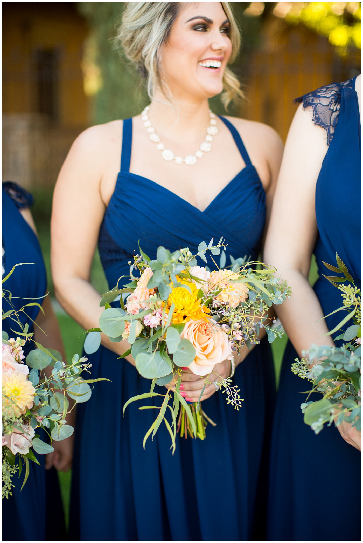 Bridesmaid bouquet with orange roses, greenery, yellow flowers