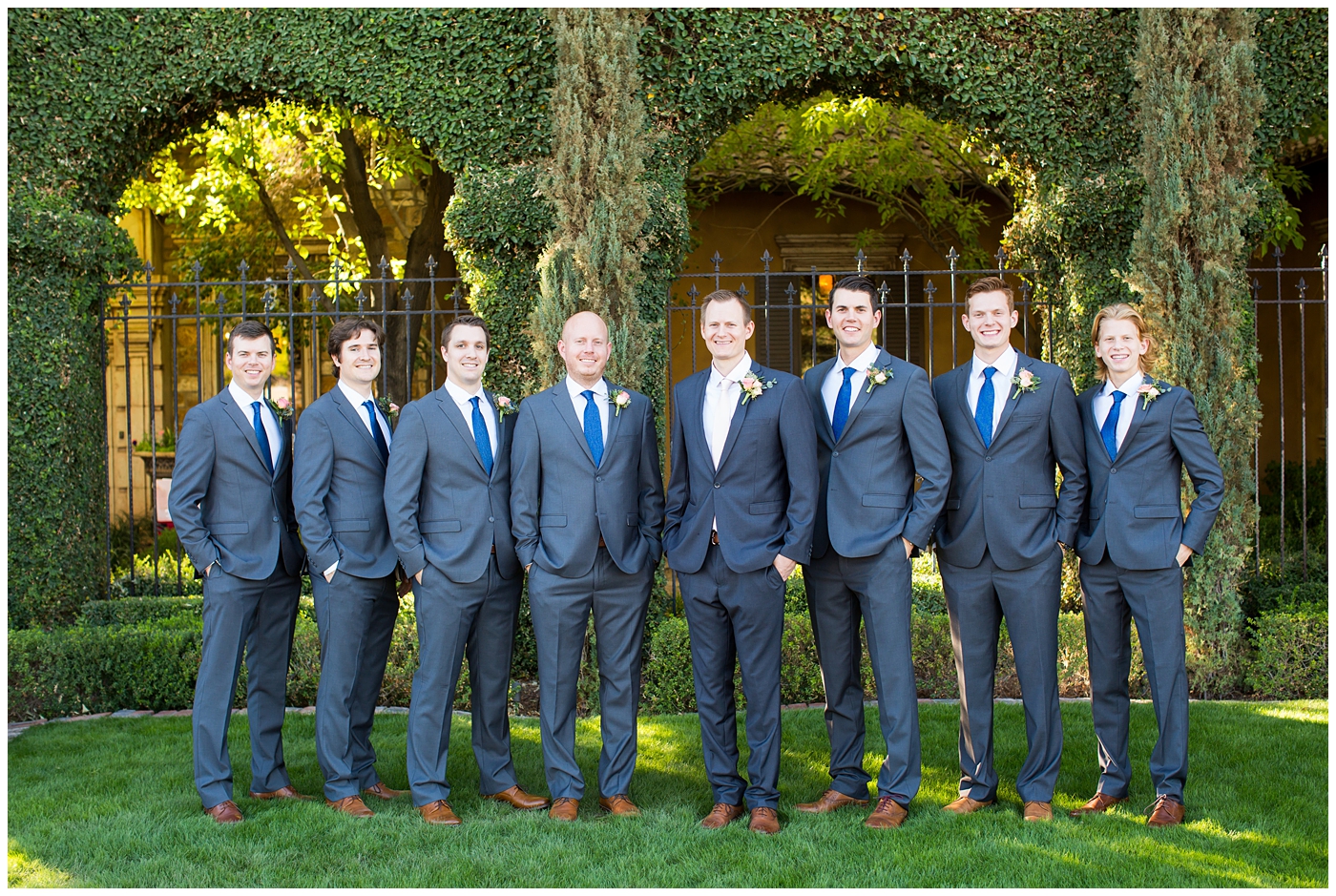 groom in gray suit with pink tie and groomsmen in gray suits with blue ties