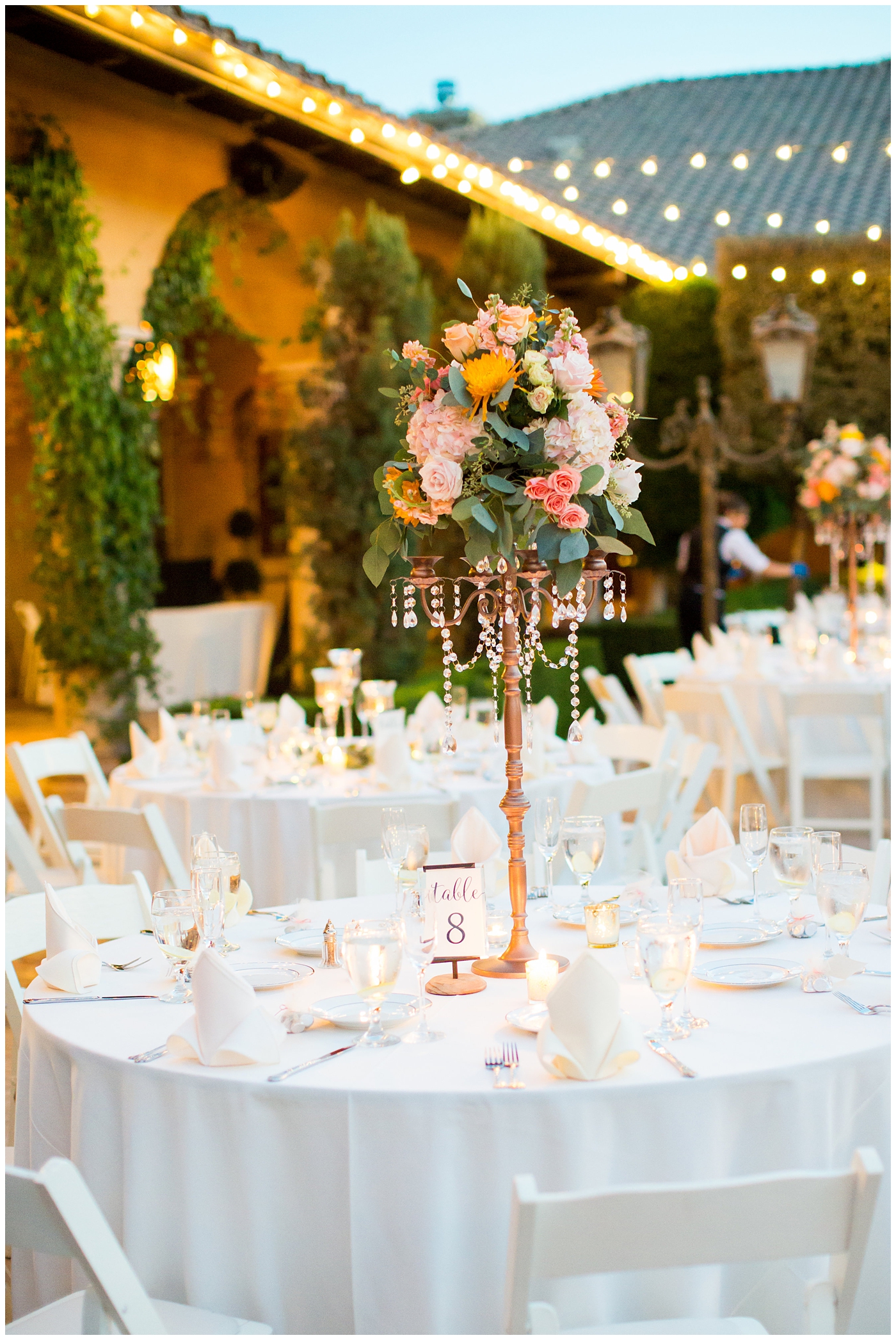 tall candelabra with orange roses, greenery, yellow flowers and jewels hanging wedding reception details