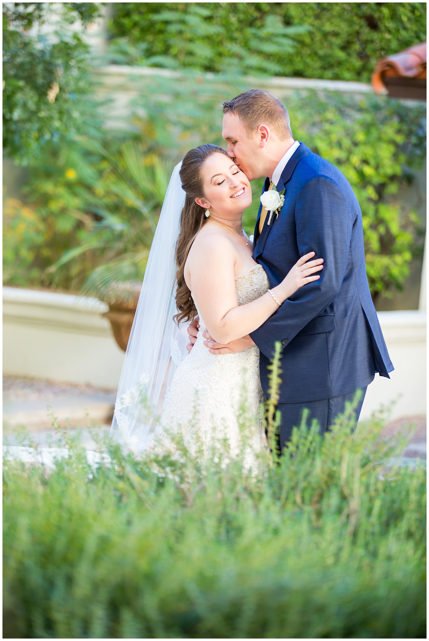 bride in lillian lottie couture wedding dress with white rose bouquet and groom in navy blue suit from men's warehouse first look