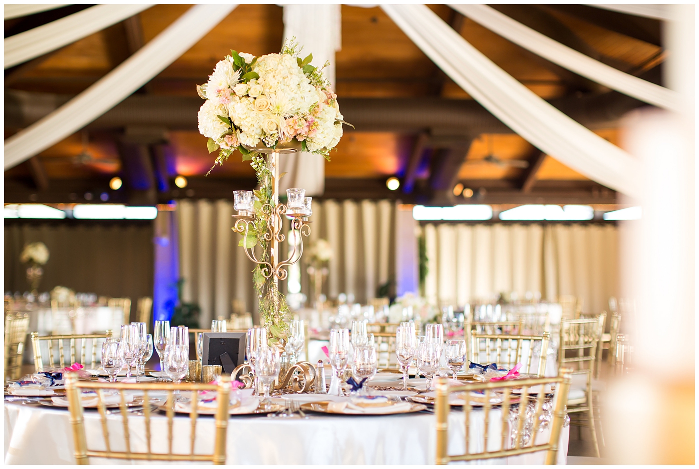 gold vase with white roses on rose gold sequin linen and gold chargers and chairs wedding reception