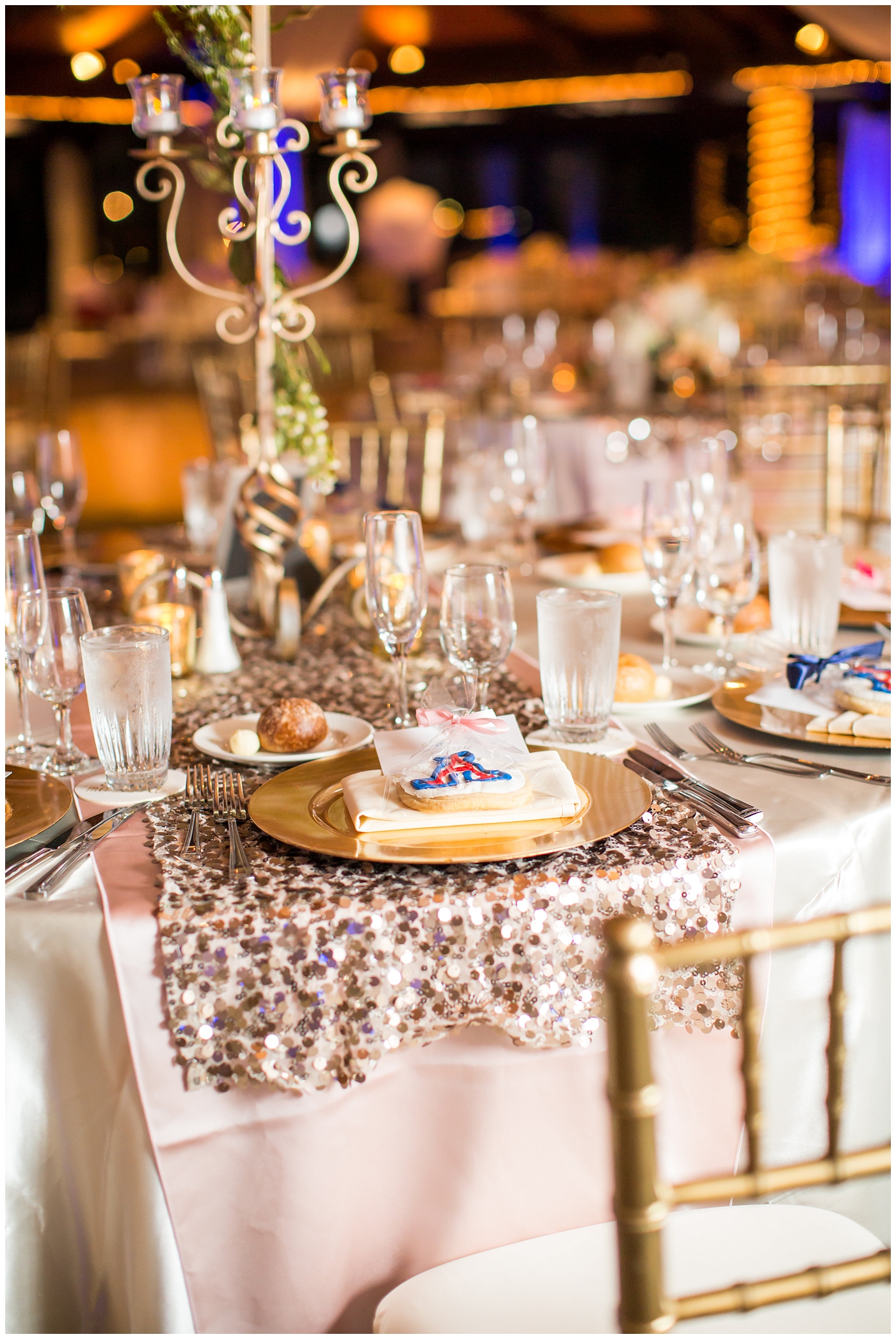 gold vase with white roses on rose gold sequin linen and gold chargers and chairs wedding reception