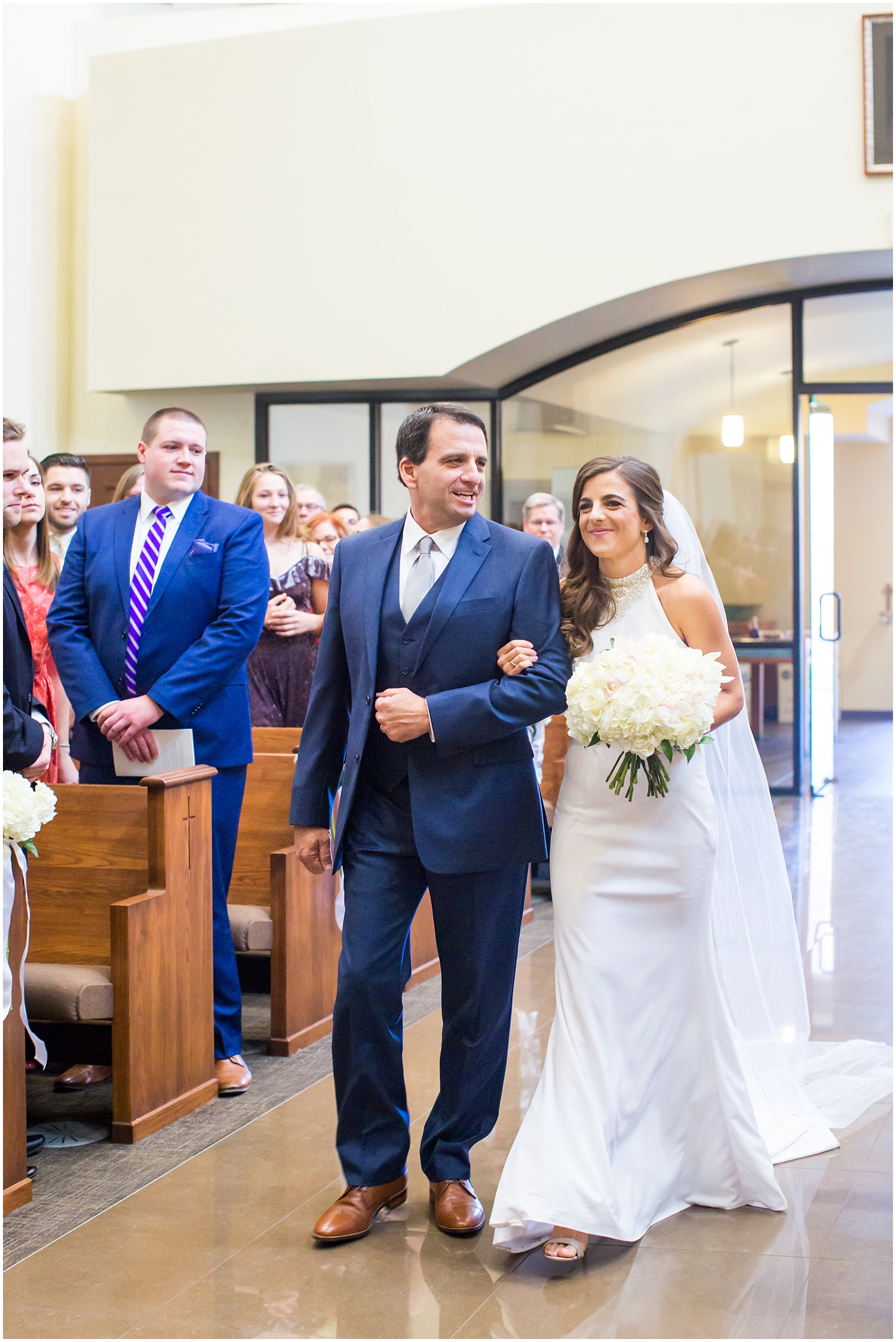 bride in demetrios bridal gown racerback with sheer beading walking down the aisle with father on wedding day