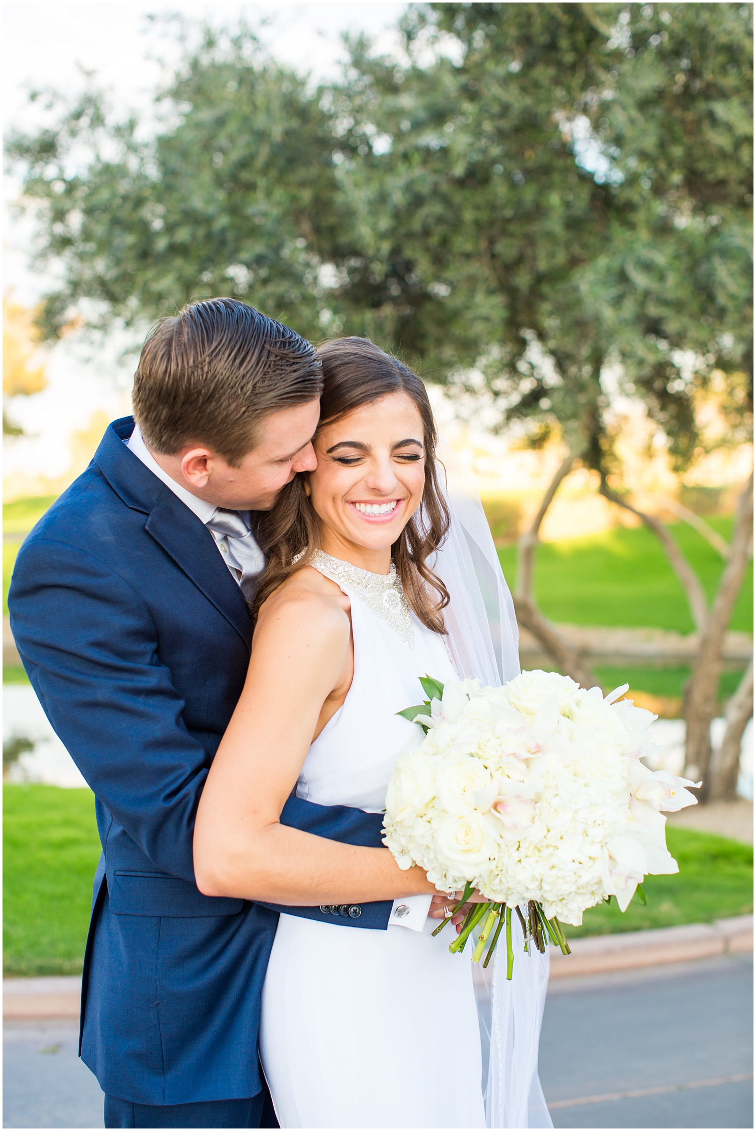 bride in demetrios bridal gown racerback with sheer beading with white hydrangeas bouquet with groom in navy blue suit with light blue tie wedding day portrait