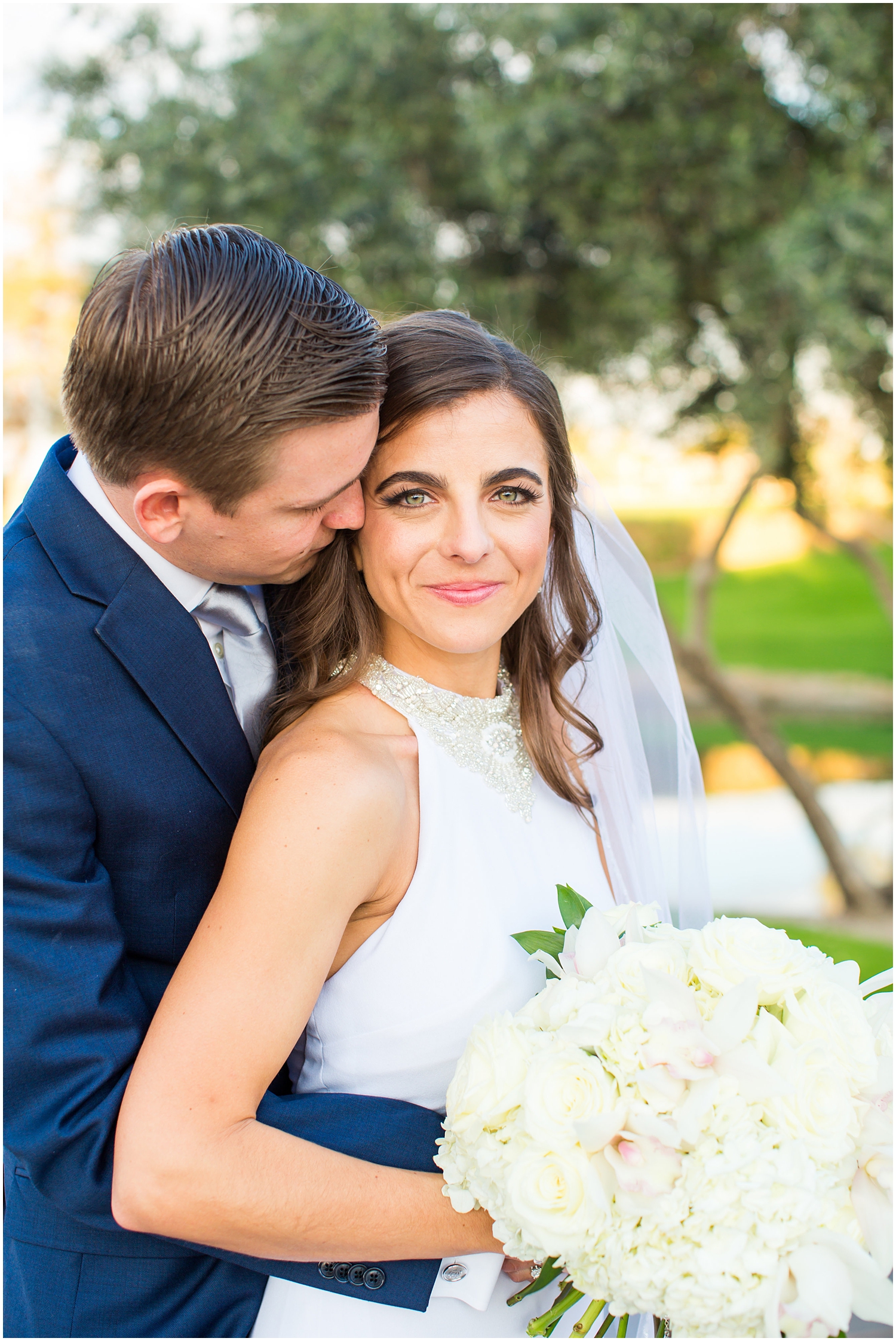 bride in demetrios bridal gown racerback with sheer beading with white hydrangeas bouquet with groom in navy blue suit with light blue tie wedding day portrait