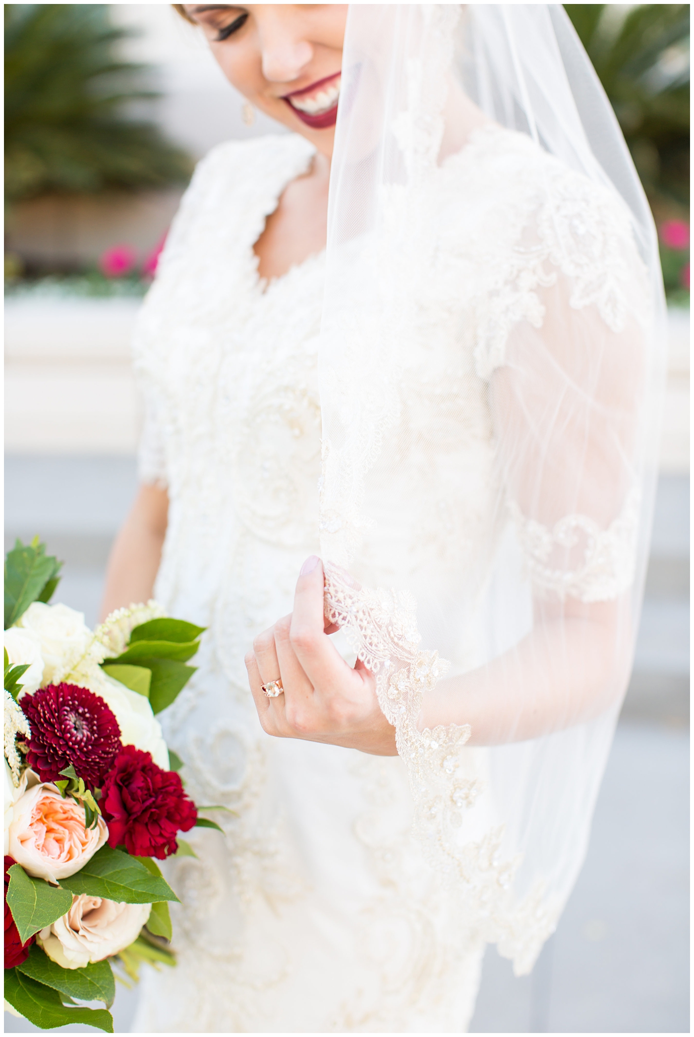 bride in sleeved lace dress with burgundy, white, and green wedding bouquet wedding day portrait at Gilbert LDS temple