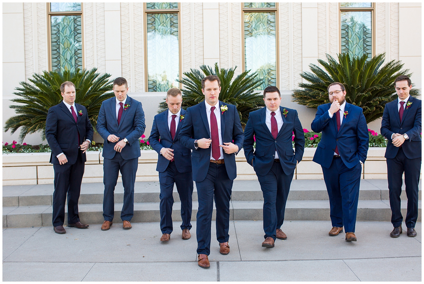 groom in navy suit with burgundy tie with groomsmen wedding party portrait at Gilbert LDS temple
