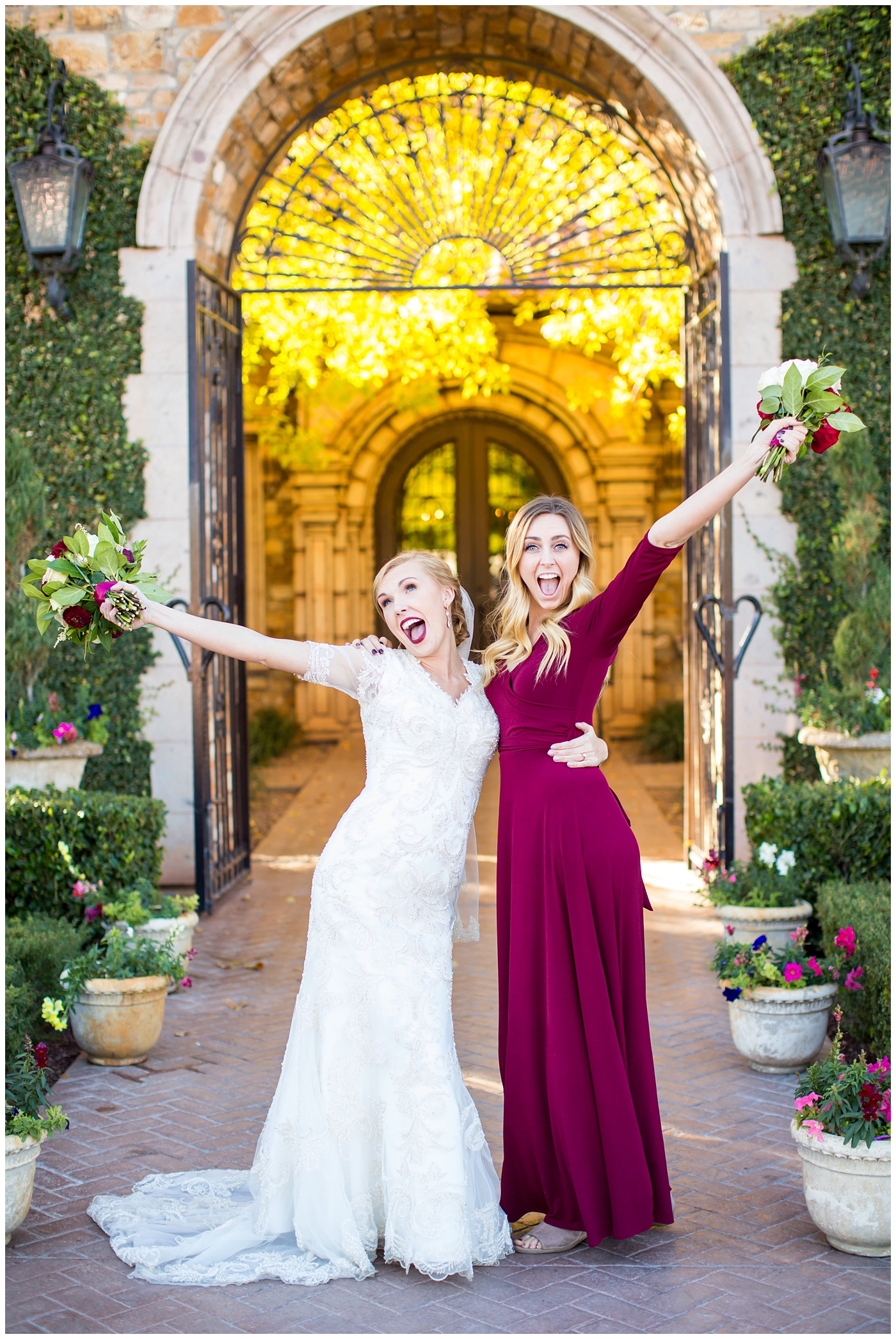 bride in sleeved lace dress with burgundy, white, and green wedding bouquet with bridesmaids in long sleeve burgundy dresses wedding day portrait at Villa Siena