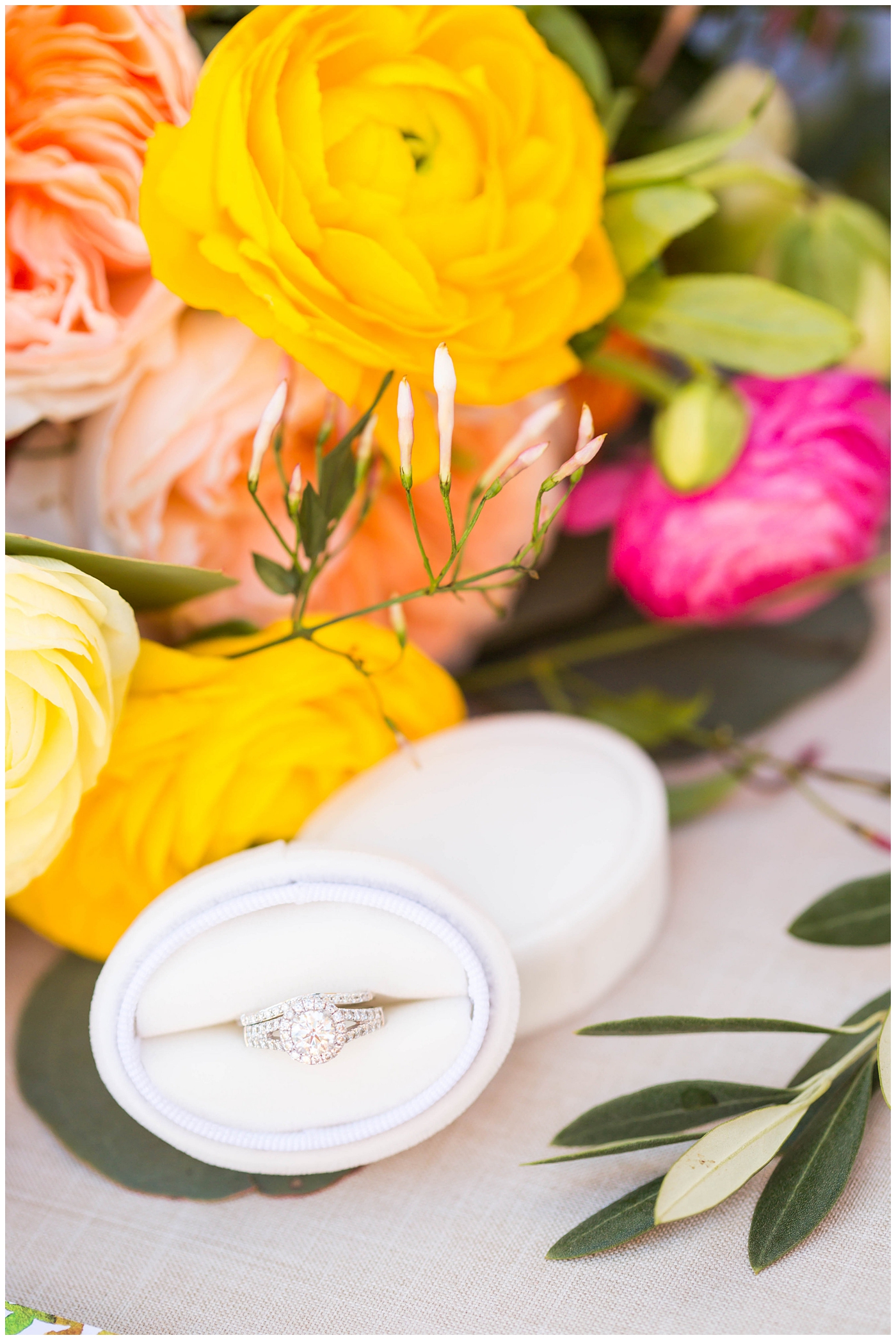 wedding ring in white mrs. box with bright floral wedding bouquet