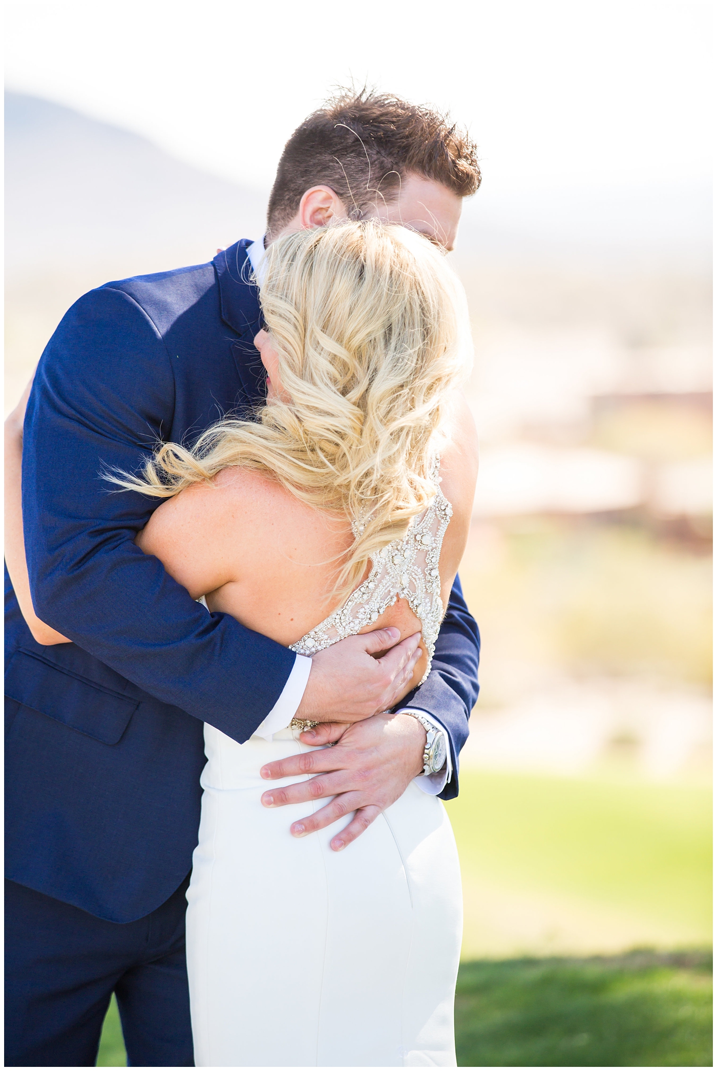 gorgeous bride with side swept hair in racerback pronovias dress with groom in navy suit and tie first look on wedding day