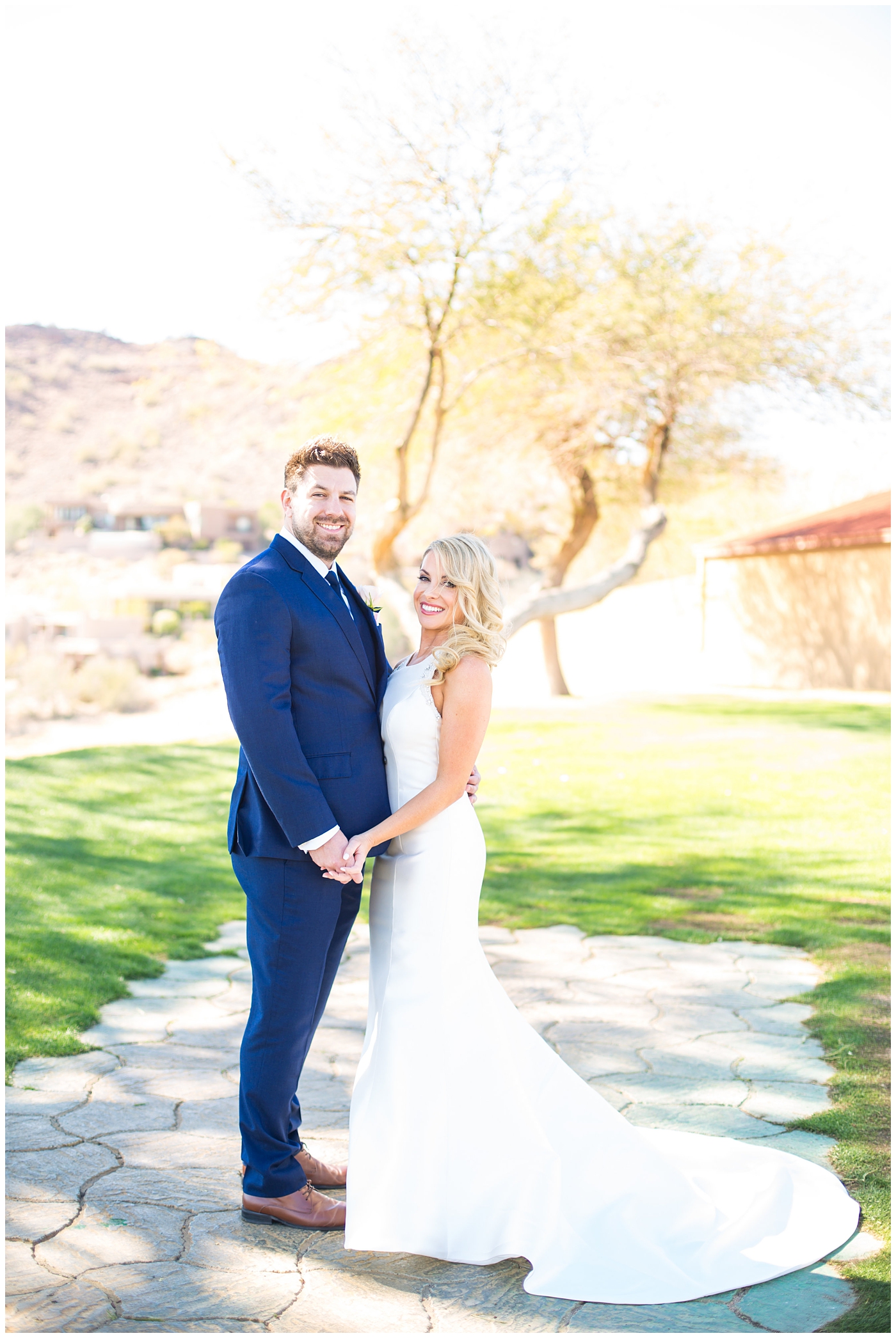 gorgeous bride with side swept hair in racerback pronovias dress with groom in navy suit and tie couple portrait on wedding day