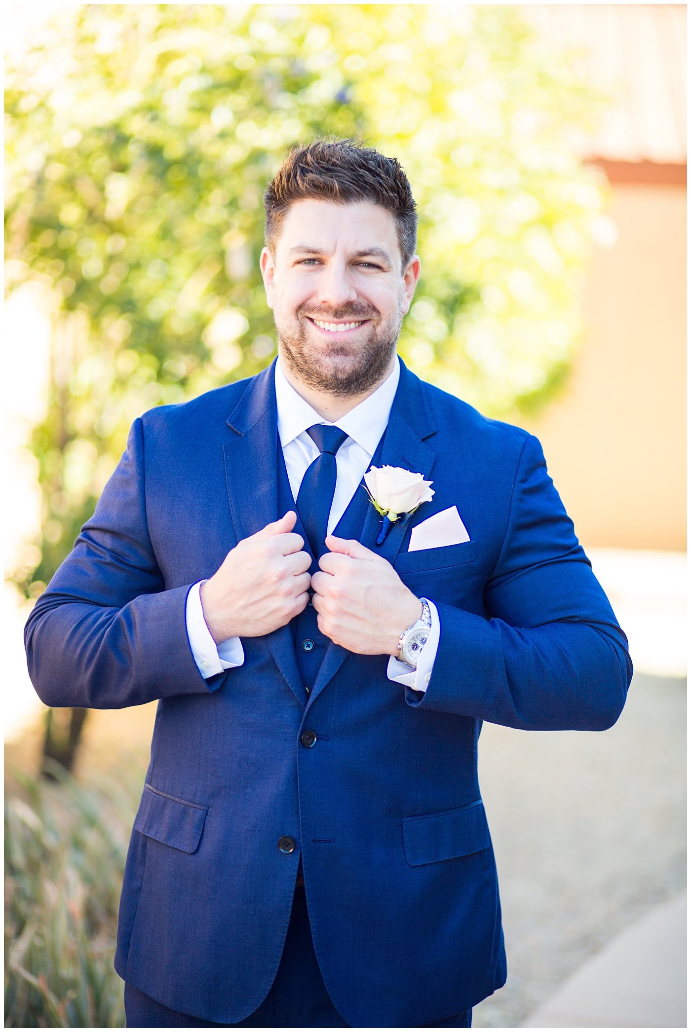 groom in navy suit and tie with blush pink boutonniere portrait