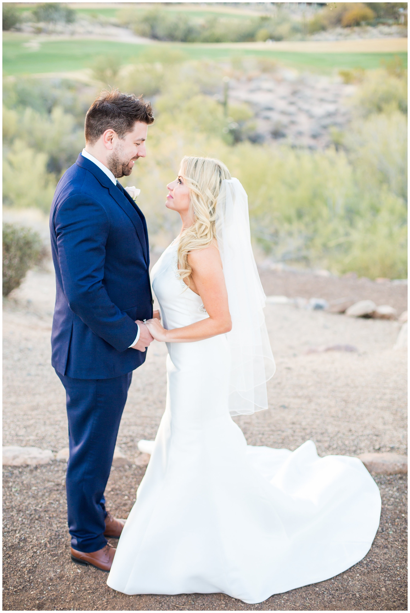 gorgeous bride with side swept hair in racerback pronovias dress and blush pink, white rose and eucalyptus greenery wedding bouquet with groom in navy suit and tie couple portrait on wedding day