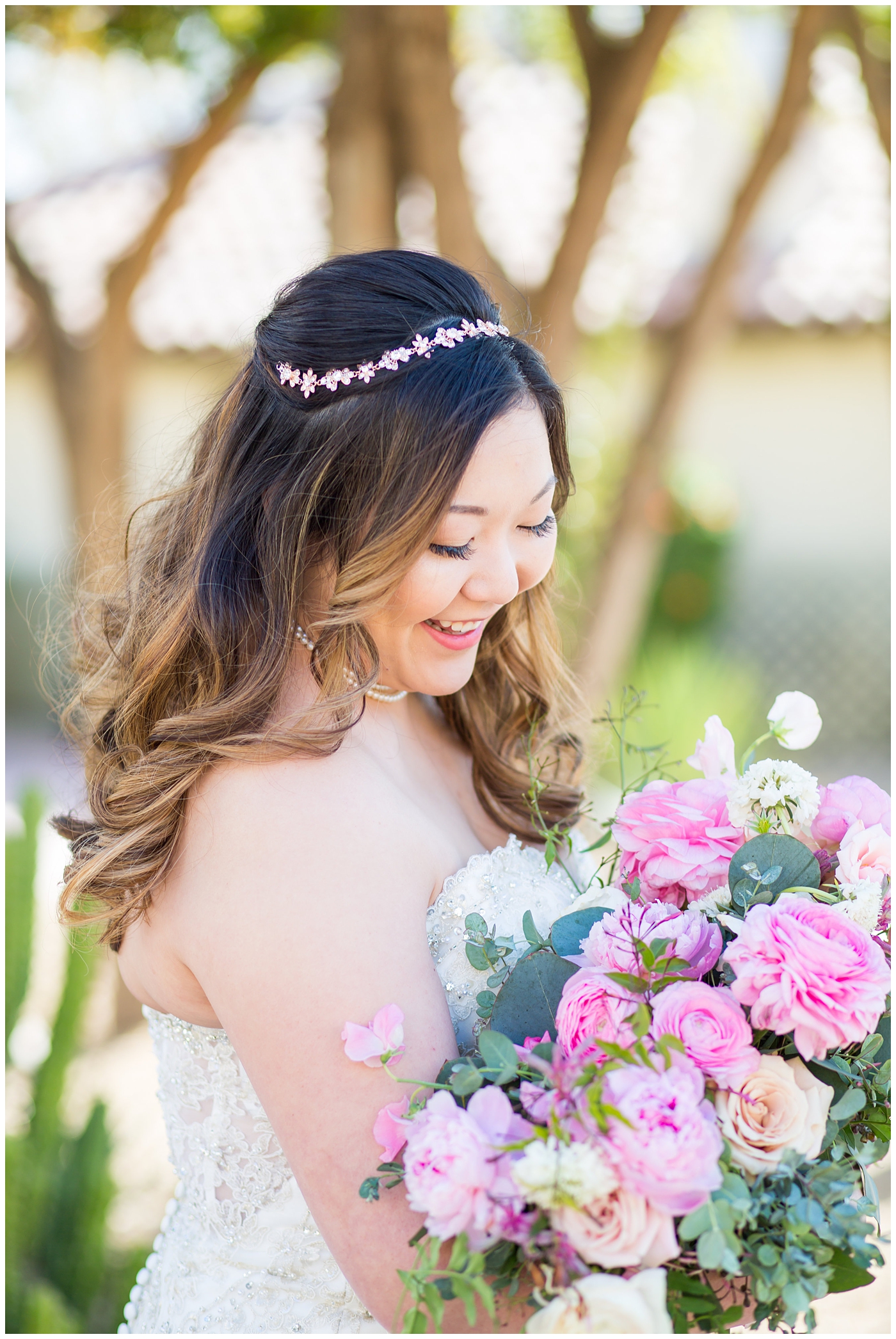 bride in strapless wedding dress with beads and shiny sparkle tool holding pink peony, roses, light coral rose and loose greenery bridal bouquet wedding day portrait