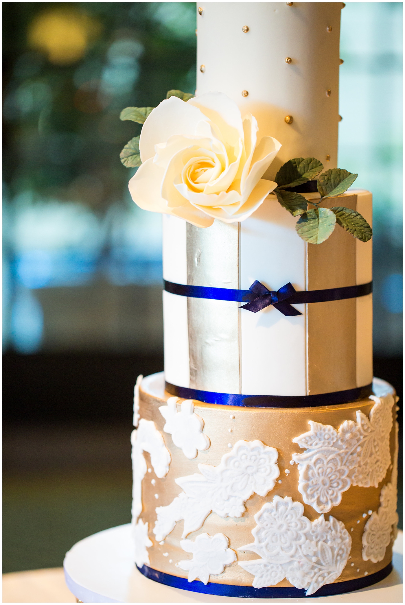 3 tier custom wedding cake with gold and lace pattern royal blue boy and rose on top wedding reception detail