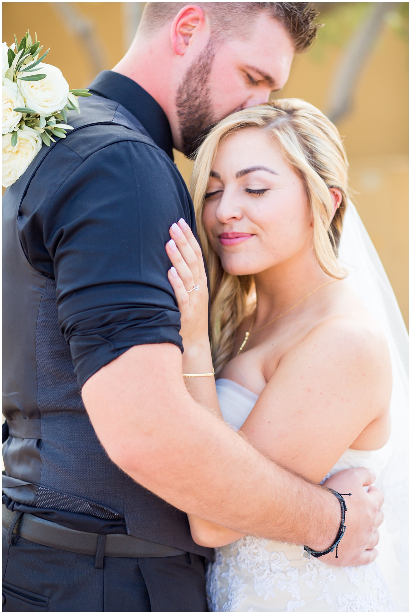 bride with fishtail braid and strapless dress with white rose and greenery bouquet with groom in black pants and vest and tie with rolled up shirt sleeves with succulent boutonniere wedding day portrait