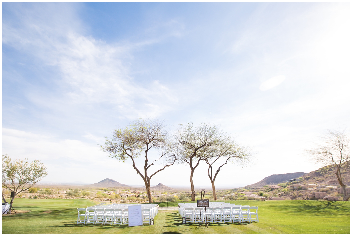 wedding ceremony set up with white folding chairs overlooking fountain hills with trees outdoors
