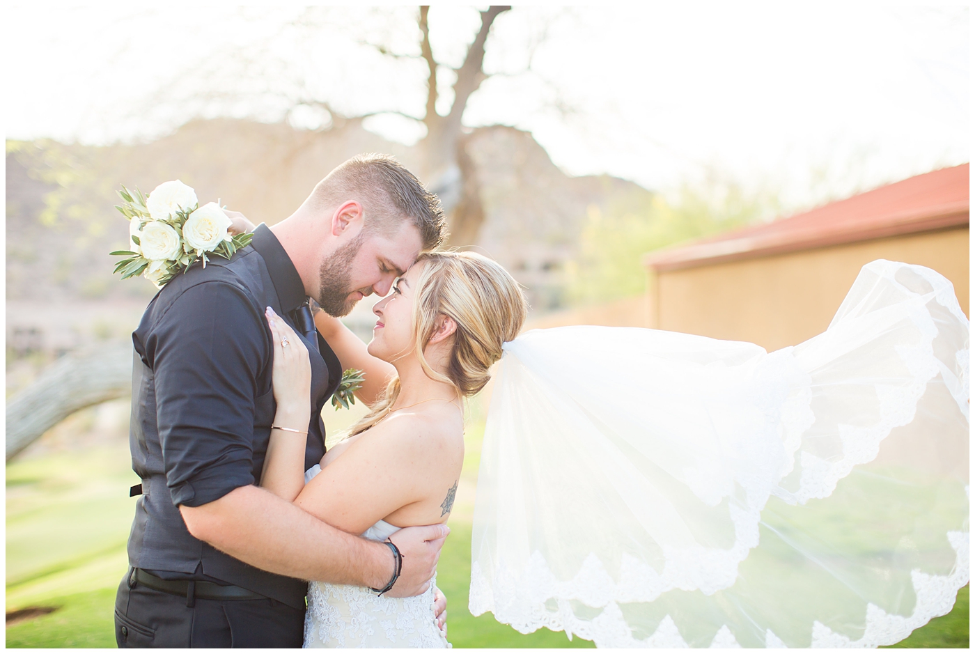 bride with fishtail braid and strapless dress with white rose and greenery bouquet with groom in black pants and vest and tie with rolled up shirt sleeves with succulent boutonniere wedding day portrait