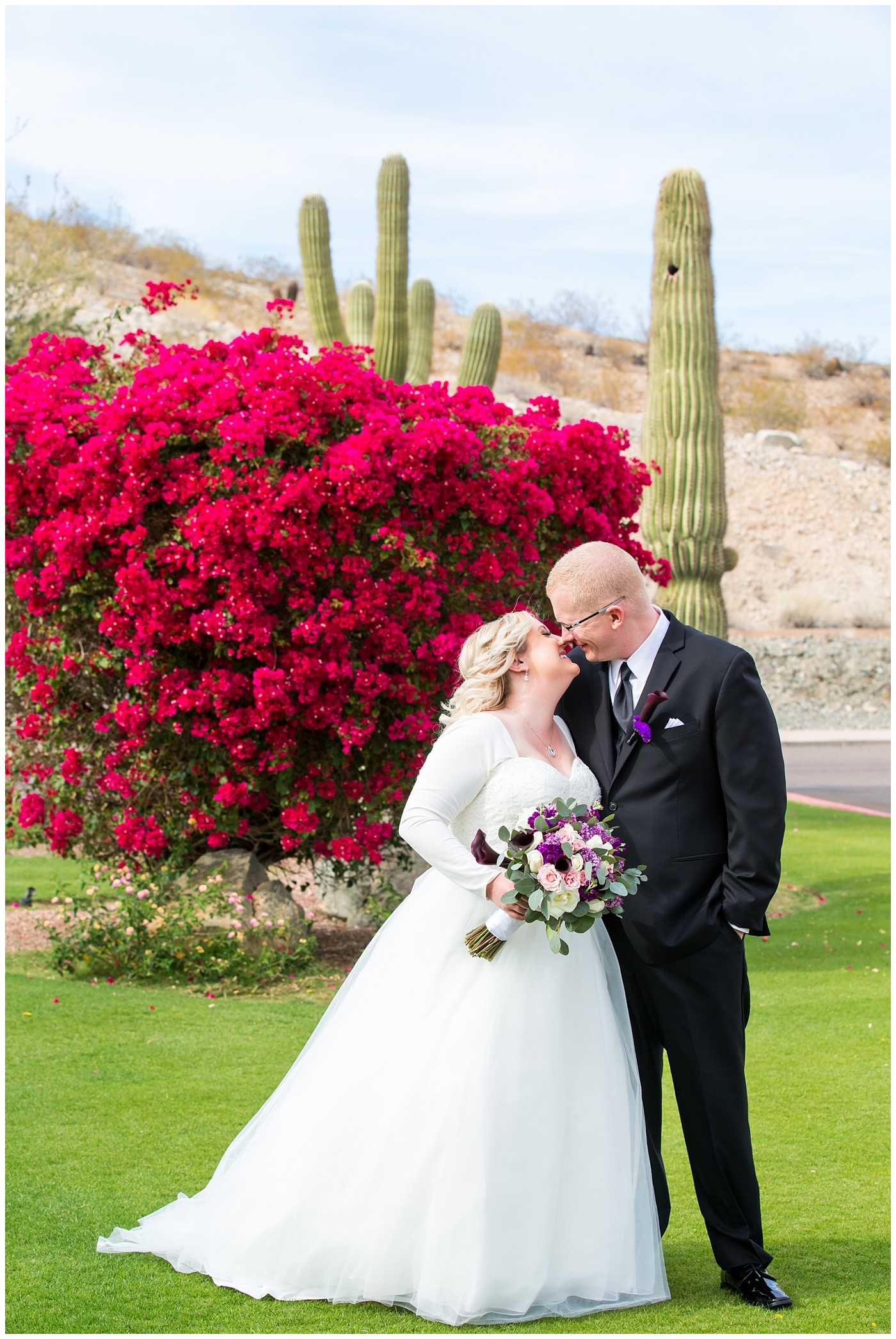 blonde bride in long sleeve wedding dress with purple and white flower bouquet and groom in black suit with purple calla lilly boutonniere wedding day portrait