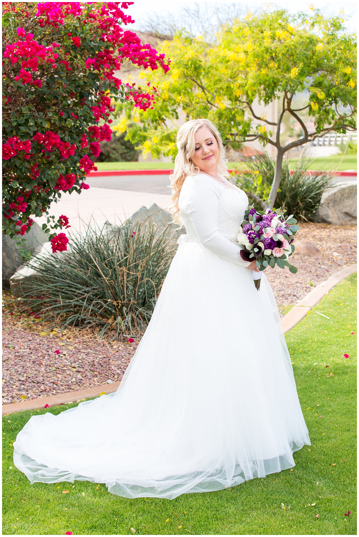 blonde bride in long sleeve wedding dress with purple and white flower bouquet wedding day portrait