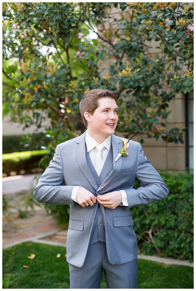 groom in light gray suit with tie tie getting ready at Arizona Biltmore