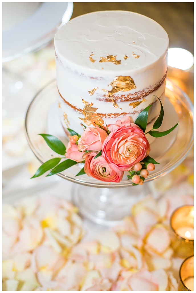 naked wedding cake with pink ranunculus with gold foil
