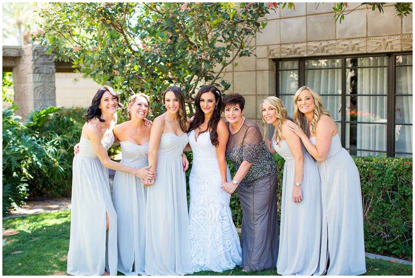 bride in dress with thin straps getting ready with bridesmaids in champagne color dresses