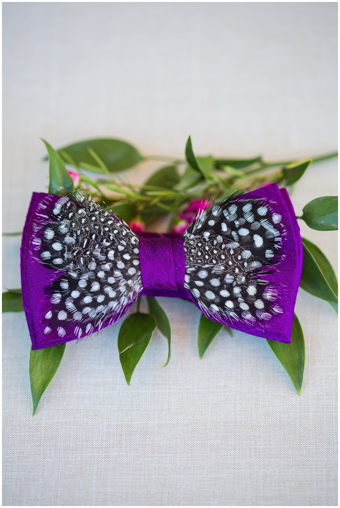 purple bowtie with black and white feather wedding day