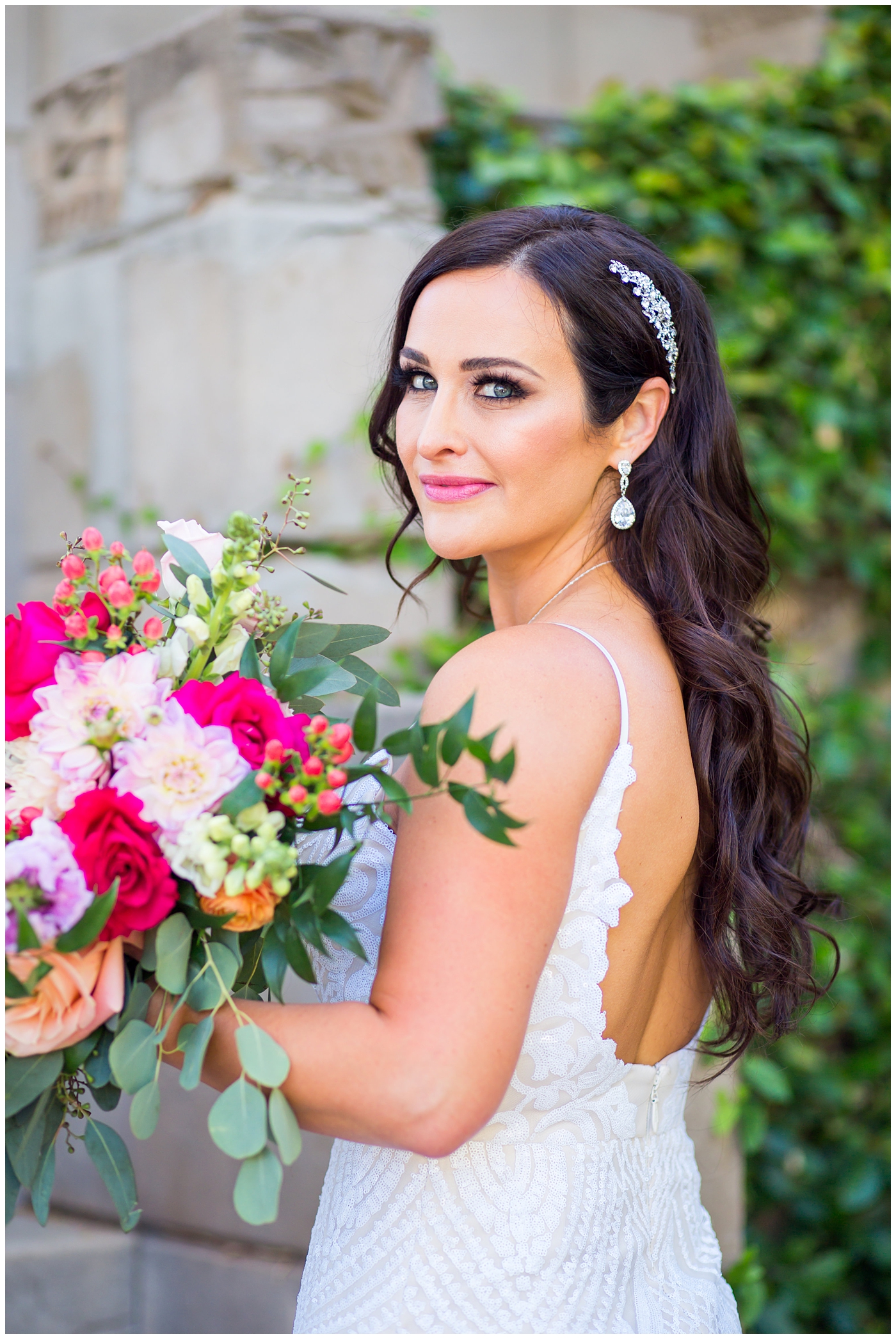 brunette bride in wedding dress with thin straps with bright color roses, dahlia, snap dragons loose bouquet wedding day portrait