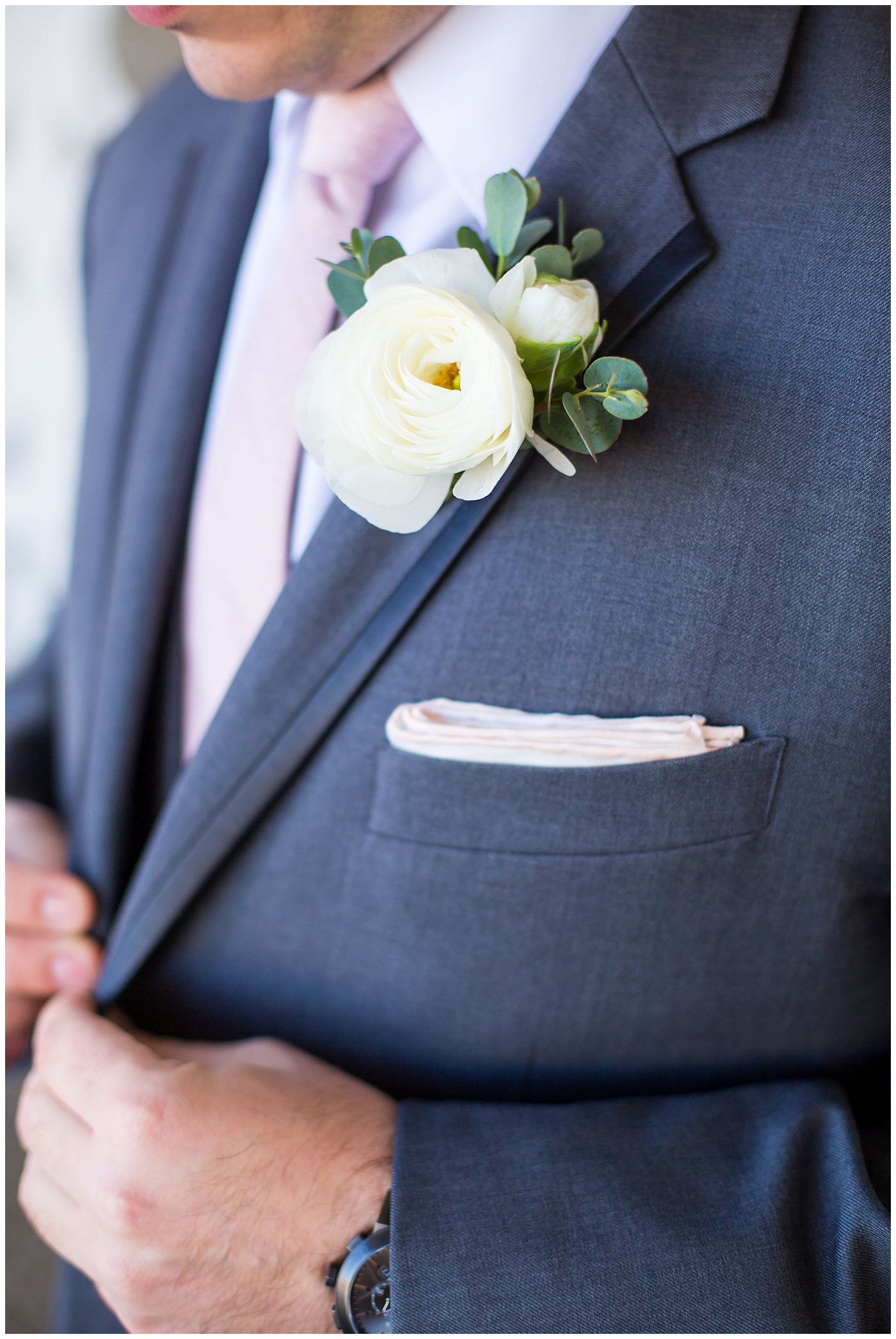 groom in gray suit with pink tie and ranunculus boutonniere portrait on wedding day