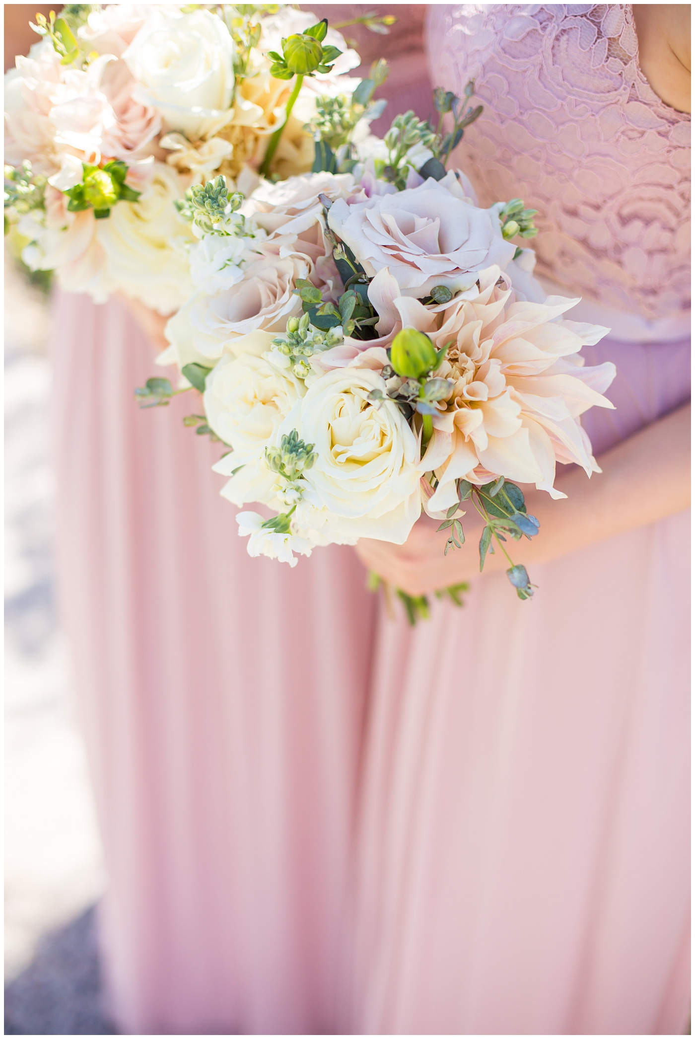 bride in wtoo watters wedding dress with lace straps with wildflower bridal bouquet with soft pink, blush, white, greenery flowers including roses, dahlias, snapdragons with bridesmaids in long blush strapped dresses wedding day portrait