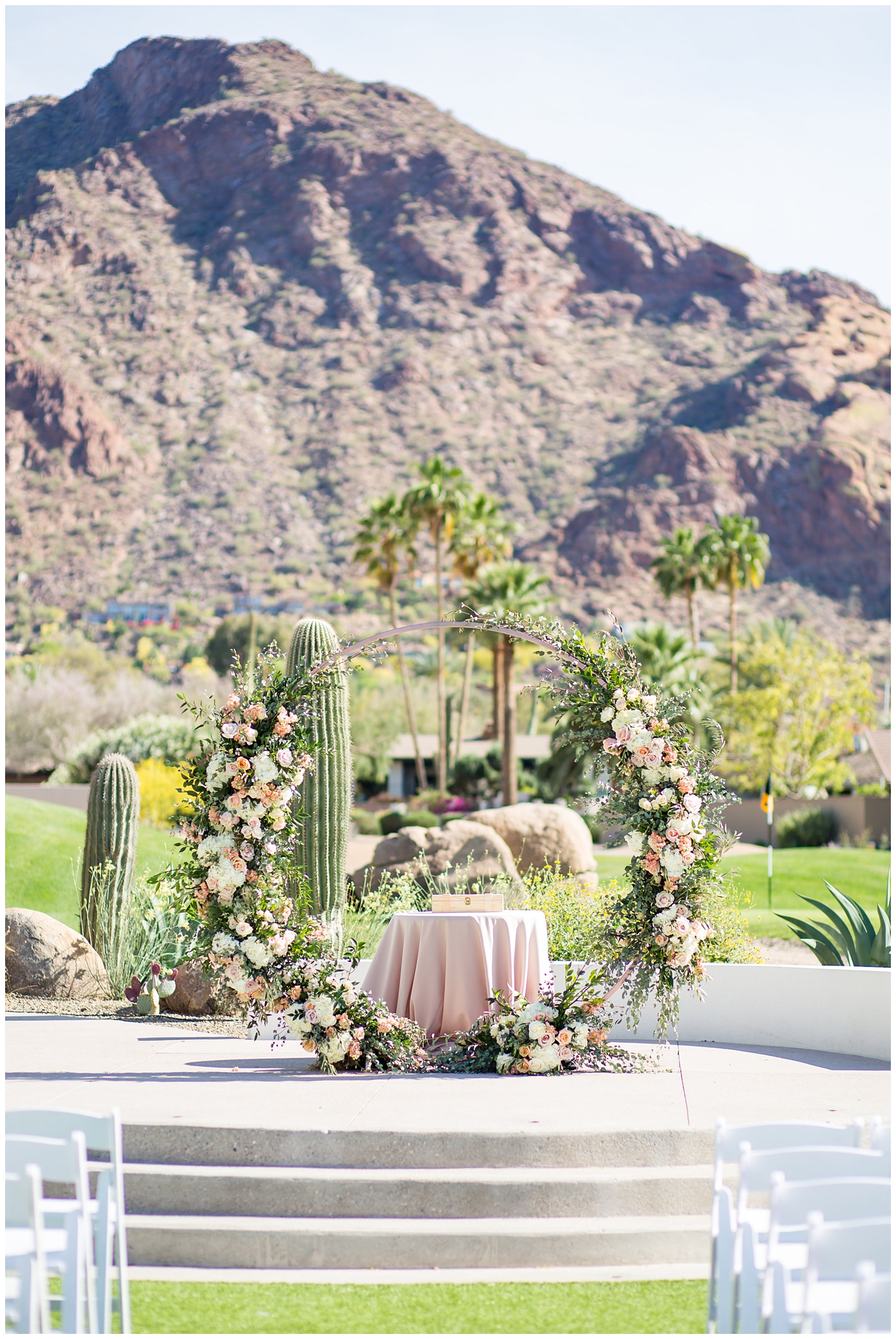 unique circle arch for ceremony with wildflowers in blush and white with greenery at wedding ceremony with mountain in background