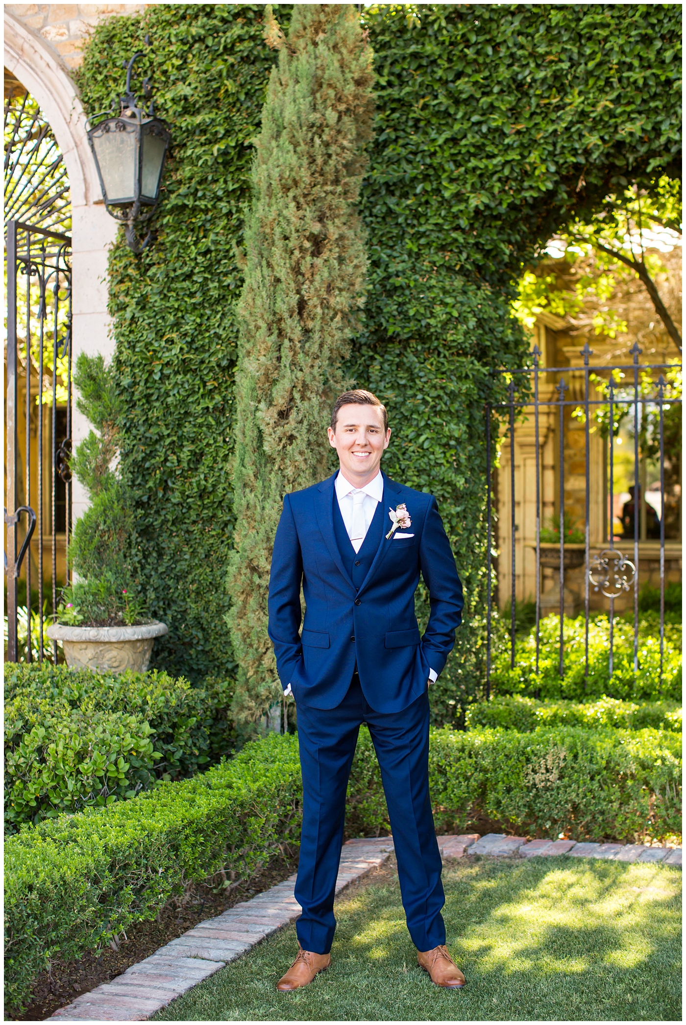 groom in blue suit with blush rose boutonniere wedding day portrait