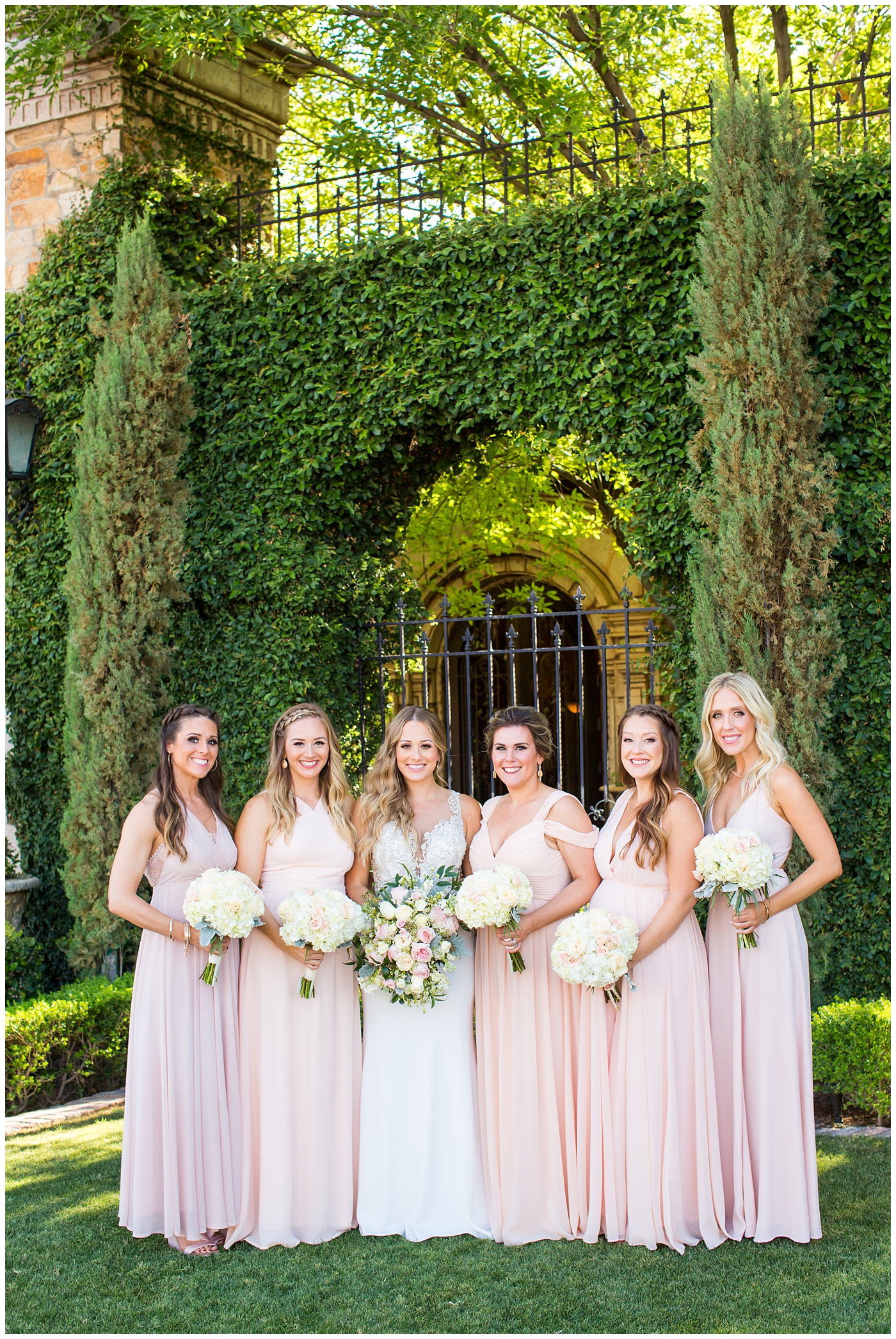 bride in lillian lottie couture strapped beaded wedding dress with bridesmaids in long blush dresses on wedding day portrait