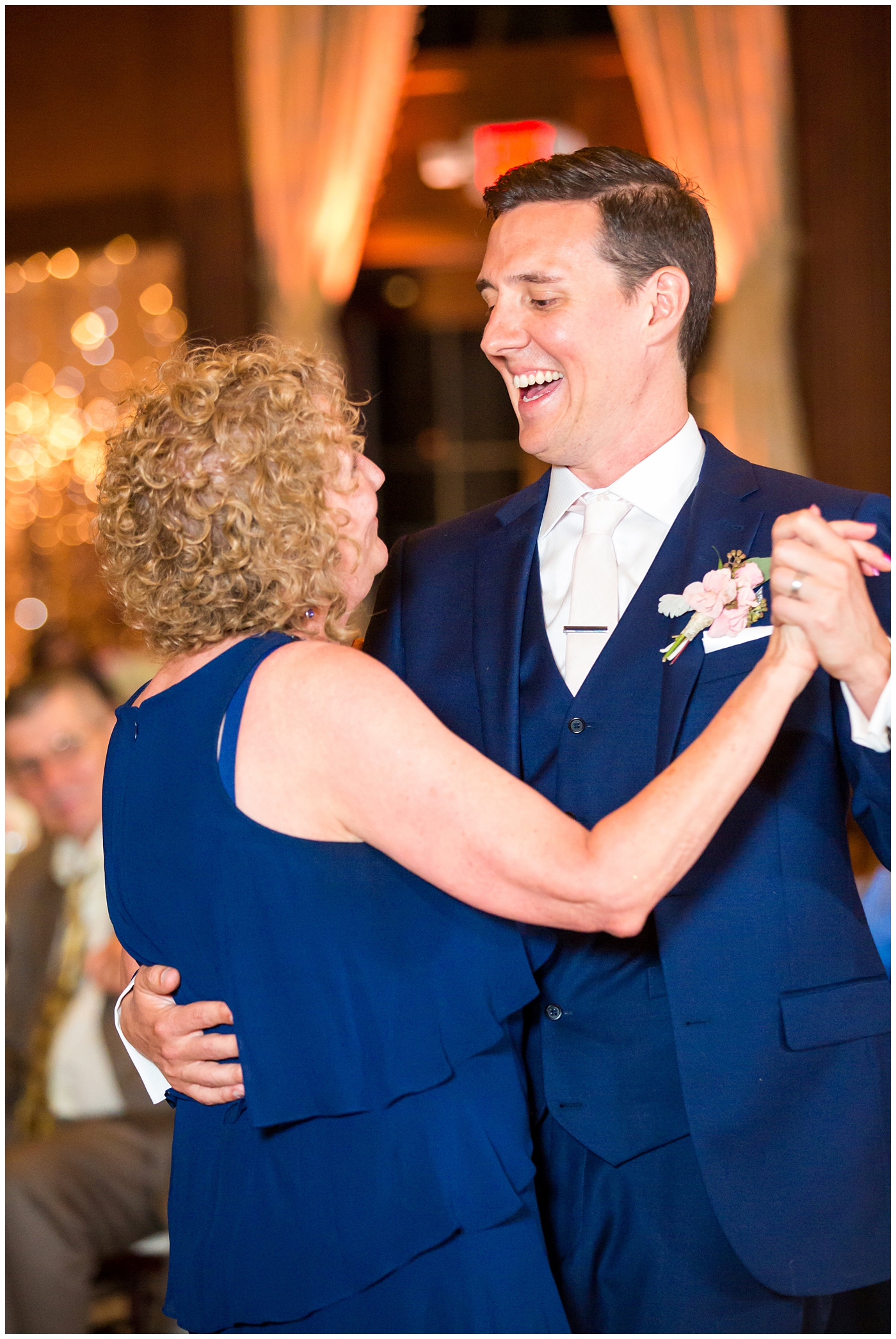 groom in blue suit with rose boutonniere with mother for mother son dance in ballroom reception