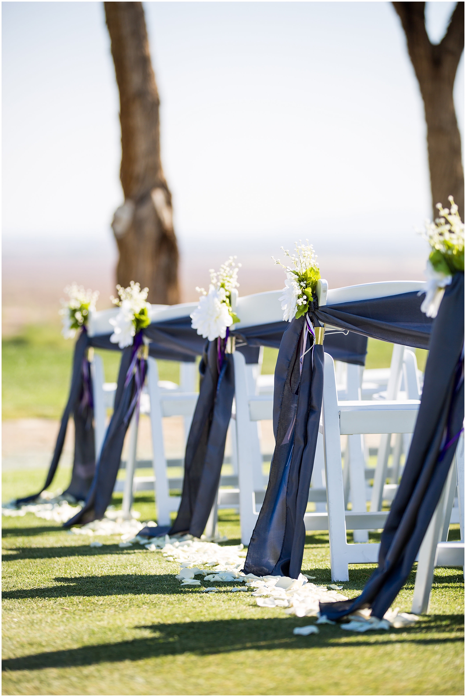 white chairs with ribbon and white flowers ceremony decoration