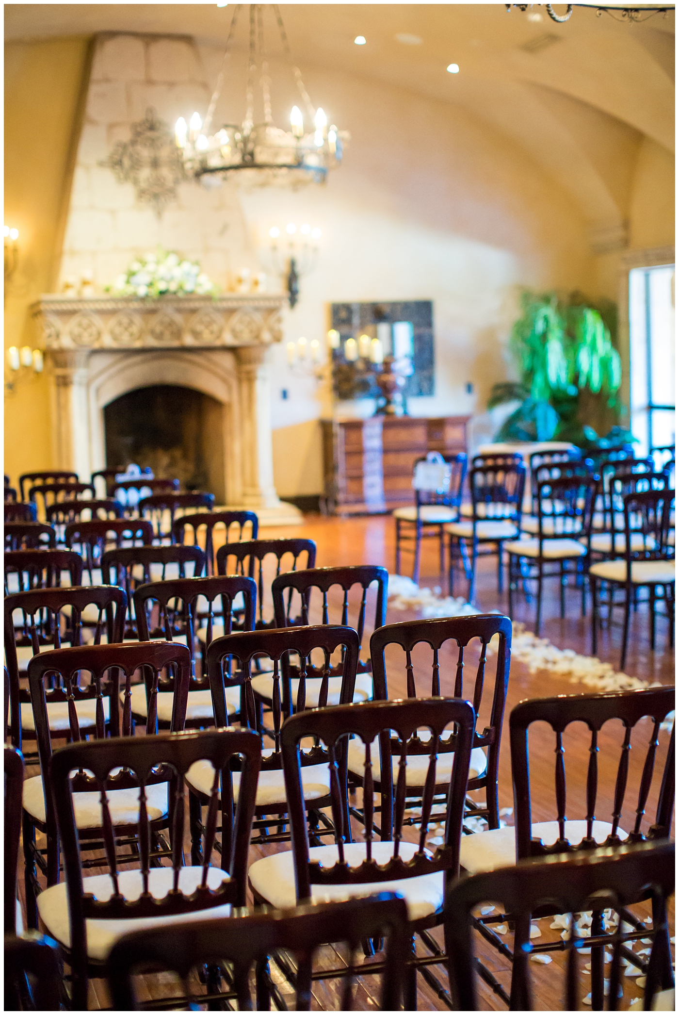 inside ceremony room with fireplace brown chairs and floral on wedding day