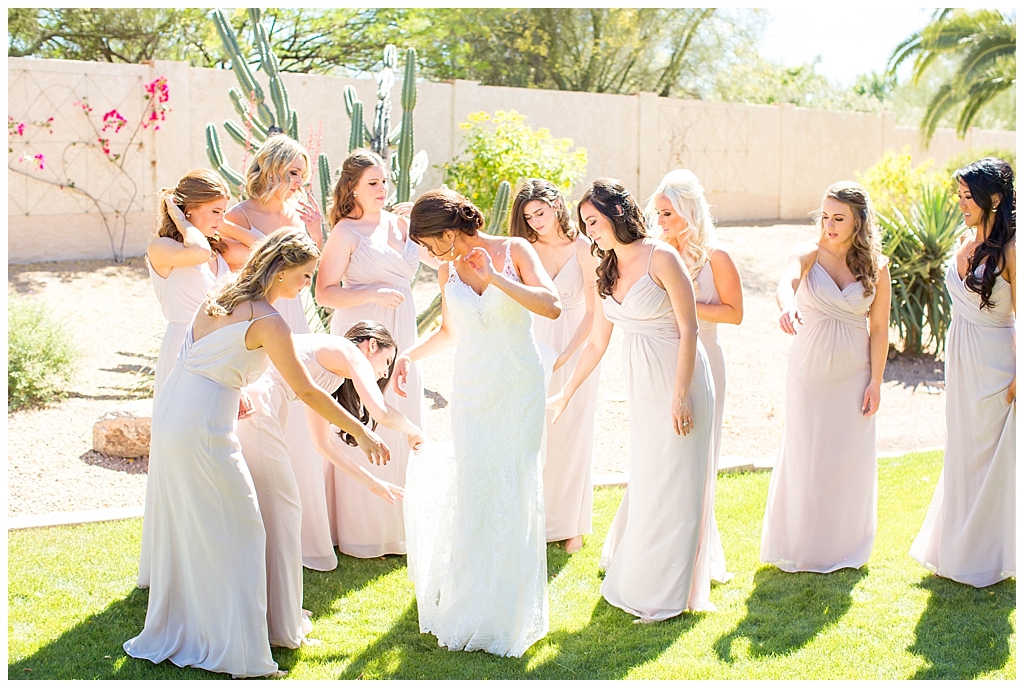 Bride getting ready with bridesmaids in blush dress
