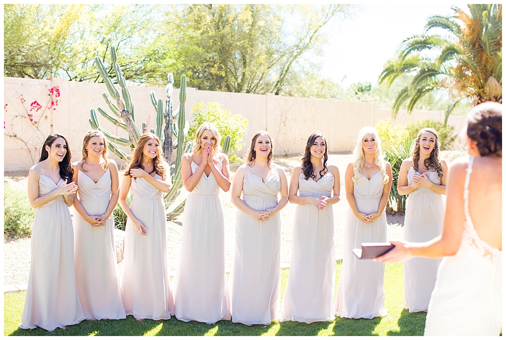 bridesmaids in blush dresses seeing bride for the first time