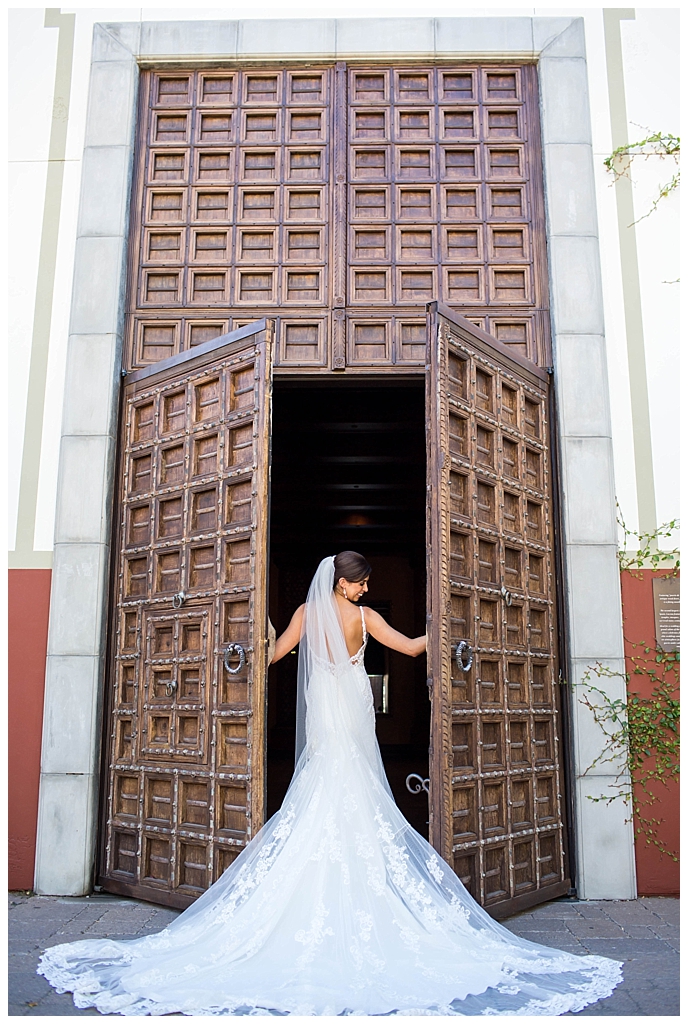 beautiful elegant bride in front of big wood doors at Omni Montelucia