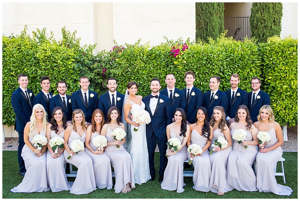 large wedding party in navy suits and mauve blush dresses with white rose wedding bouquets
