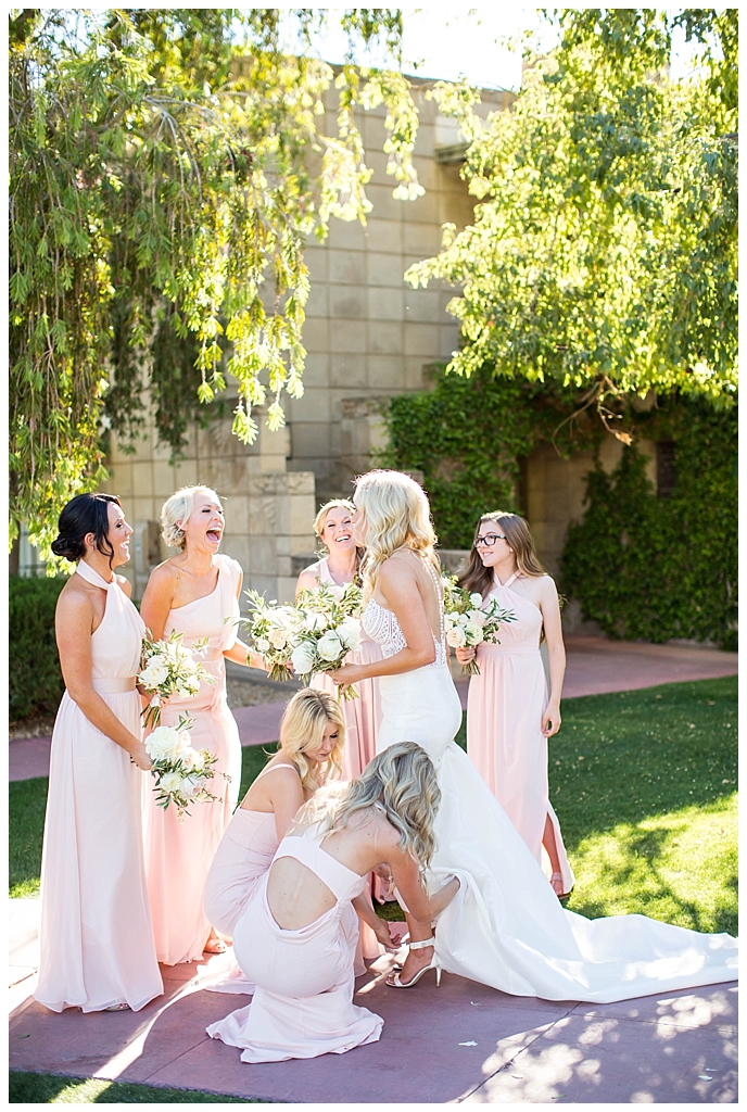 Bride getting ready with bridesmaids in blush dresses and white bouquets